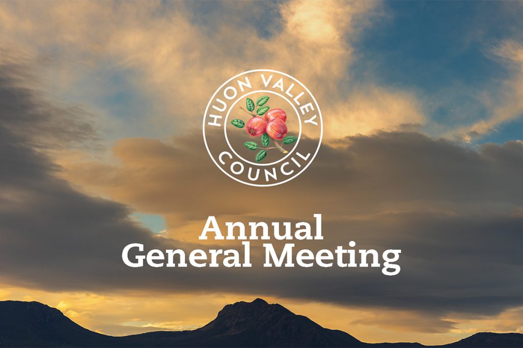 A scenic image of a sunset sky with clouds over a silhouette of mountains. The Huon Valley Council logo with peaches is at the top center, and the text Annual General Meeting is below it.
