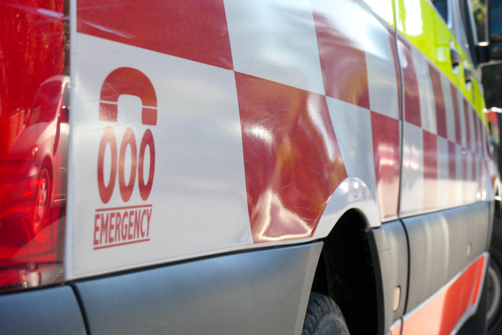 Close-up of an emergency vehicle with red and white checkered pattern and the number 000 displayed, indicating an emergency contact number in Australia.