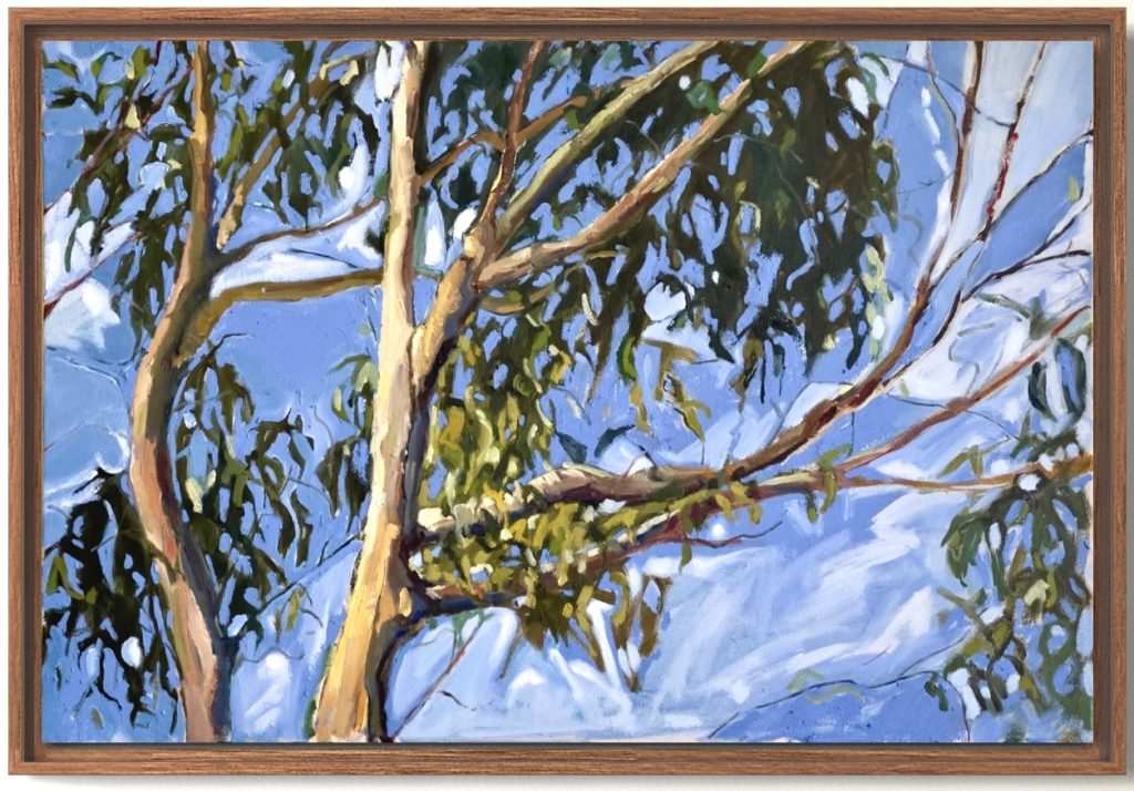 A framed painting of tree branches with green leaves against a bright blue sky with white clouds, depicted in a realistic yet expressive style.