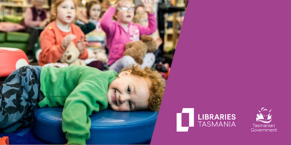 A young child smiles while lying on a blue cushion, with other children playing and clapping in the background. The right side features the Libraries Tasmania and Tasmanian Government logos on a purple background.
