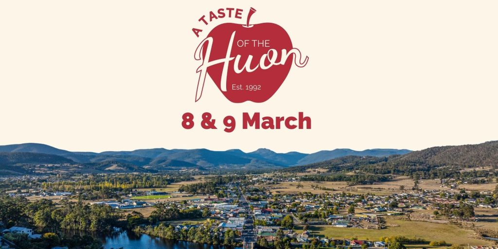 Aerial view of a town with a river and hills, featuring A Taste of the Huon Est. 1992 logo with a red apple, and event dates 8 & 9 March displayed prominently above the landscape.